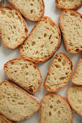 Bread and pastries. Pattern of slices of white ciabatta bread on a white wooden background. Background image, copy space. Top view, flatlay