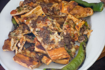 Pita, also known as Turkey's pizza, is a kind of flatbread prepared with kebab meat, grilled chicken, cheddar cheese, tomatoes and spices, served with roasted peppers and hot pickle peppers.