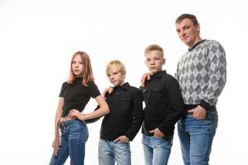 Fototapeta premium Dad, two sons and a daughter in casual clothes in dark colors, white background