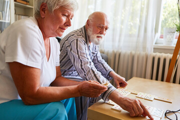 Senioren spielen zu Hause oder im Seniorenheim Domino