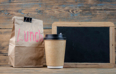 Paper bag and blackboard on wood background with a notes lunch