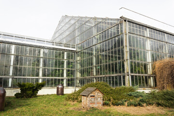 Naklejka na ściany i meble Poznan, Poland - February 24, 2022: Greenhouse building in the Park Wilsona with palms inside. Glass building.