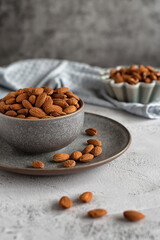 Ceramic bowl with almonds on a gray marble table