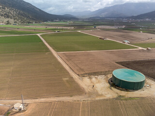 Farm fields with rows of green lettuce salad. Aerial view on agricultural valley Zafarraya with...