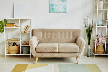 Minimal home interior with comfy velvet couch in neutral beige tone, copy space