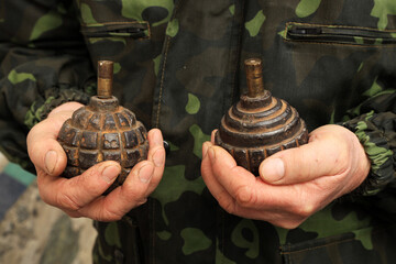 Old rusty grenades in hands of a soldier