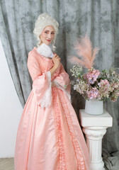 Fototapeta premium Young pretty woman closeup in pink royal dress. Marie Antoinette cosplay