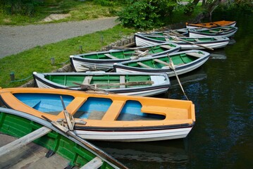 Fototapeta na wymiar Lots of rowing boats for hire lies at the quay side in an amusement park in Bornholm.