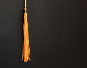 Graduation concept with academical tassel on balck background