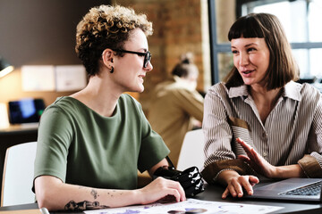 Girl with disability having business interview with businesswoman at the table with laptop