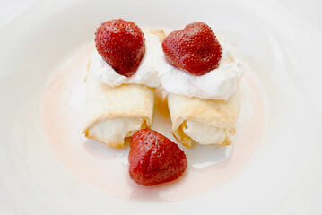 Cheese Crepes Served with Whipped Cream and Strawberries