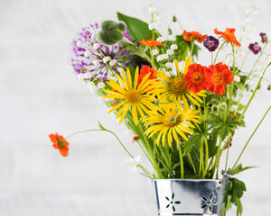 Beautiful summer flowers in a metal bucket. Summer background. Copy space.