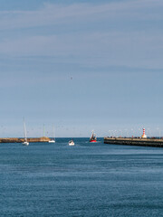 A fishing boat leaves Amble harbour in Northumberland, UK with copy space