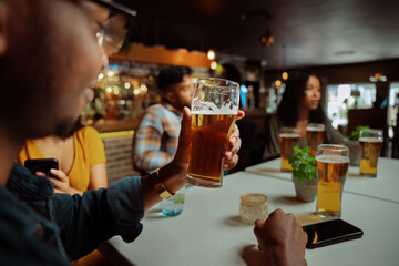 diverse group of friends out for dinner enjoying cold beverage 