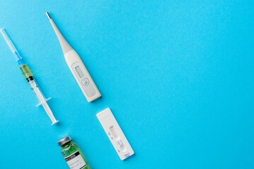 The concept of rapid testing for coronavirus and vaccination. Positive self test kit and covid-19 vaccines, pinkf background, flat view