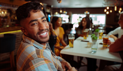 african Ameirican male smiling while out for drinks with friends 