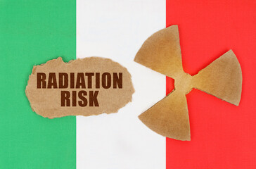 On the flag of Italy, the symbol of radioactivity and torn cardboard with the inscription -...