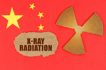 On the flag of China, the symbol of radioactivity and torn cardboard with the inscription - X-Ray Radiation