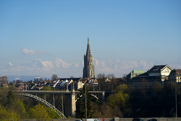 Fototapeta premium View over the old town of Bern with church Berner Minster and Swiss Alps in the background on a sunny spring afternoon. Photo taken April 4th, 2022, Bern, Switzerland.