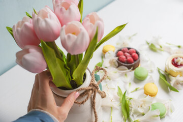 The process of preparing for the holiday of Easter and spring, Mother's Day. Easter holiday celebration. A woman's hand lays out cute decorations.