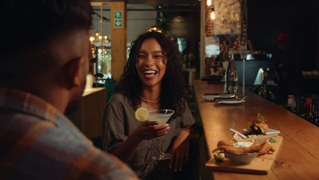 African American female on date with boyfriend drinking cocktails