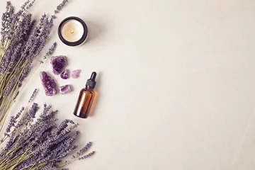 Fotobehang Glass bottle of Lavender essential oil with lavender flowers and candles and amethyst crystals. Meditation, zen, aromatherapy,spa massage concept © netrun78