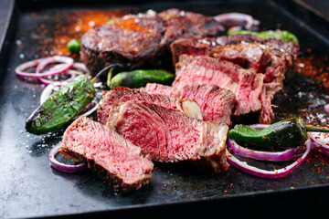 Traditional barbecue dry aged wagyu rib-eye beef steaks served with paprika and onion rings as...