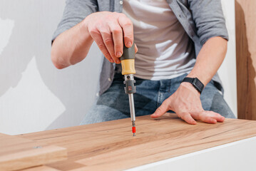 Man screwing a screw into furniture