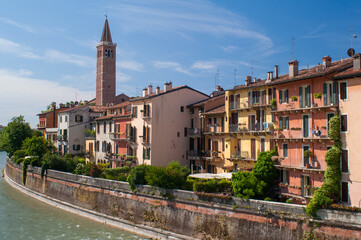 Fototapeta na wymiar View of Verona with church and row of houses on the river
