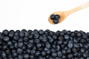Blueberry background. Ripe berries with wooden spoon on white background.