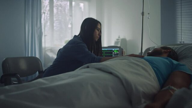 Woman comfort sick man in hospital ward. Modern clinic operating room interior.