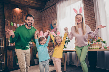 Fototapeta premium Portrait of four excited overjoyed people have fun hold arms wear bunny rabbit ears house indoors