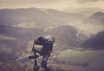 Mountain scene with camera on a tripod in vintage colors as a background for a website