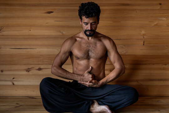 Latin American male yogi seated in the Limgan Mudra position. Concept of yoga and meditation