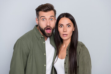 Photo of young couple astonished fake gossip stupor face reaction isolated over grey color background