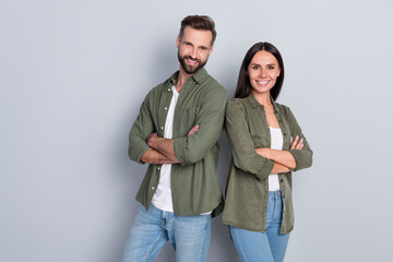 Portrait of attractive successful cheerful couple team folded arms best friends isolated over grey...