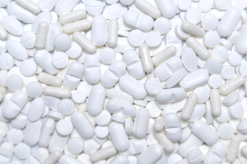 White pills, tablets and capsules background texture. Medicine and health care.