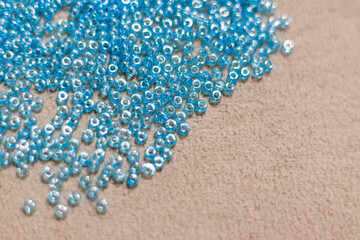 small blue beads lie scattered on the textile surface