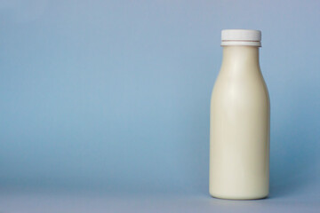 A bottle of white milk, highlighted on a blue background, close-up.