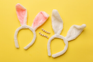 Bunny rabbit ears and Text Happy Easter on yellow background. Easter minimal concept. Flat lay