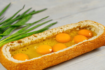 huge sandwich with raw eggs inside. Stuffed big ciabatta bread with raw ingredients ready to bake in the oven. the process of making pie or snacks. close up