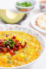 Plate with tripe soup, called mondongo, traditional food from Colombia, South America, on light wood. Also called callos, guatita, tripa mishque, pancita, menudo.