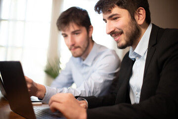 deux jeunes employés de bureau ou hommes d'affaires travaillent ensemble avec des ordinateurs...