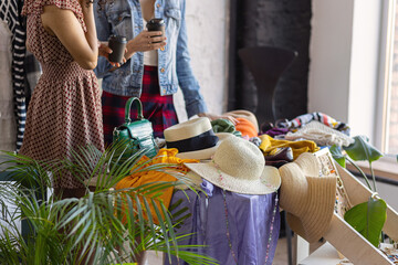 Young women at swap home party - clothes, shoes, bags, jewellery exchange between friends. Zero waste shopping, eco friendly concept, sustainable lifestyle. College life