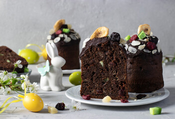 Chocolate Easter Cakes with candied fruits, as well as colorful eggs on a gray background. Easter spring still life