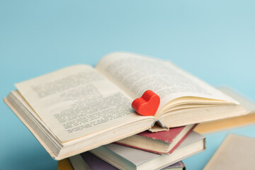 Old vintage books and heart shape wooden piece. World books day