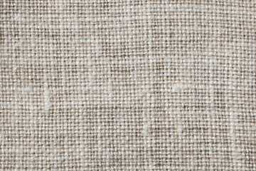 Fototapeta na wymiar Texture of gray linen fabric close-up. Interlacing threads of uneven thickness.