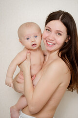 beautiful and gentle naked mom and baby against the wall