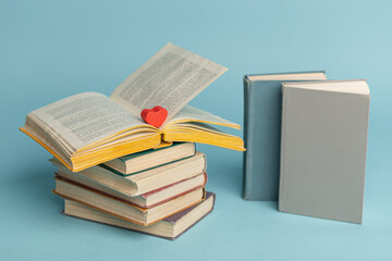 Old vintage books and heart shape wooden piece. World books day