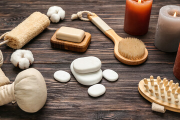 Fototapeta na wymiar Bathing supplies with spa stones and aroma candles on wooden background